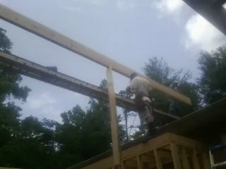 Carpenter setting a ridge beam over a new addition frame — Ice Dam Removal by Roofing Brothers in Harrisburg
